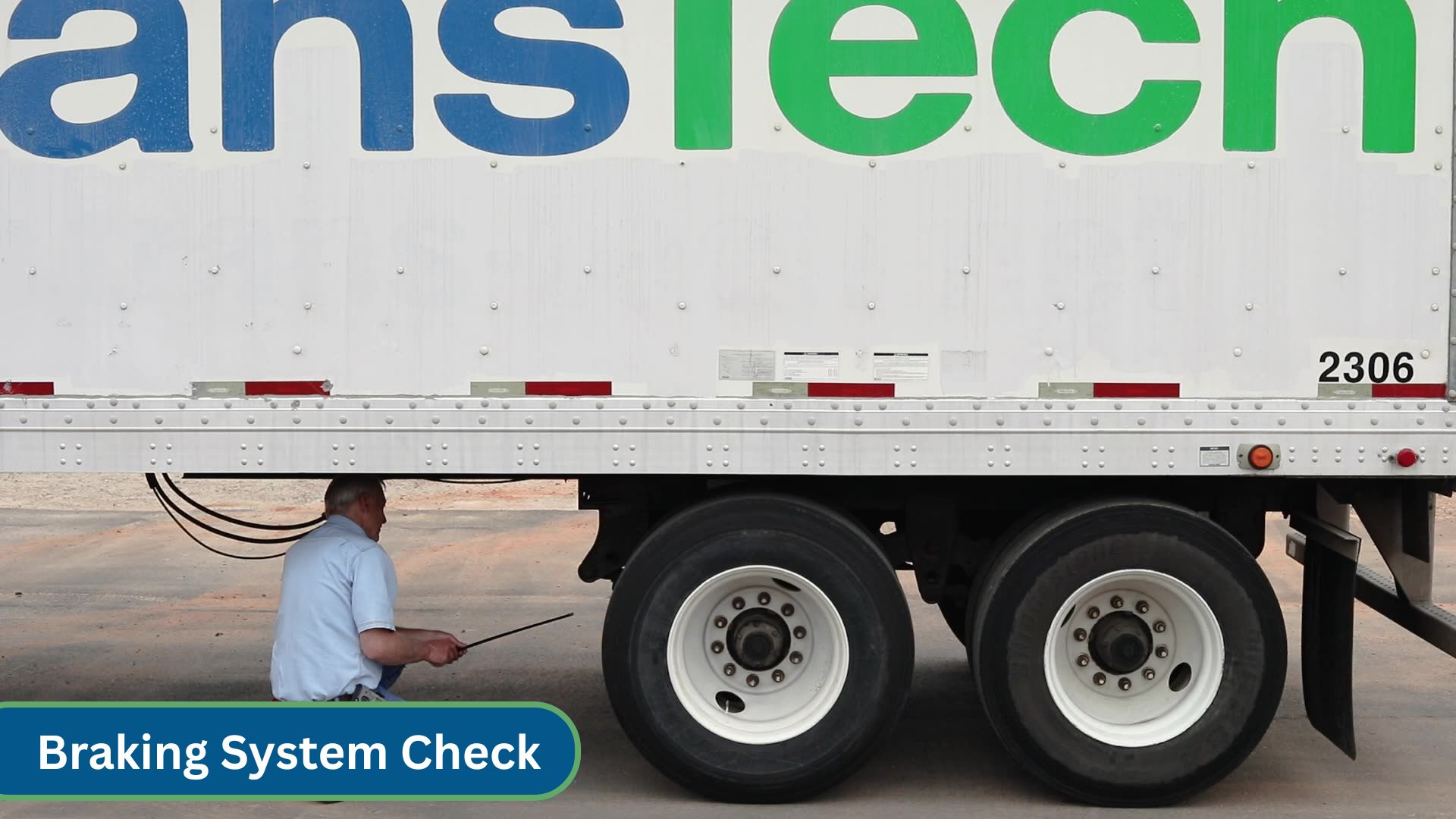 instructor viewing brake system under trailer