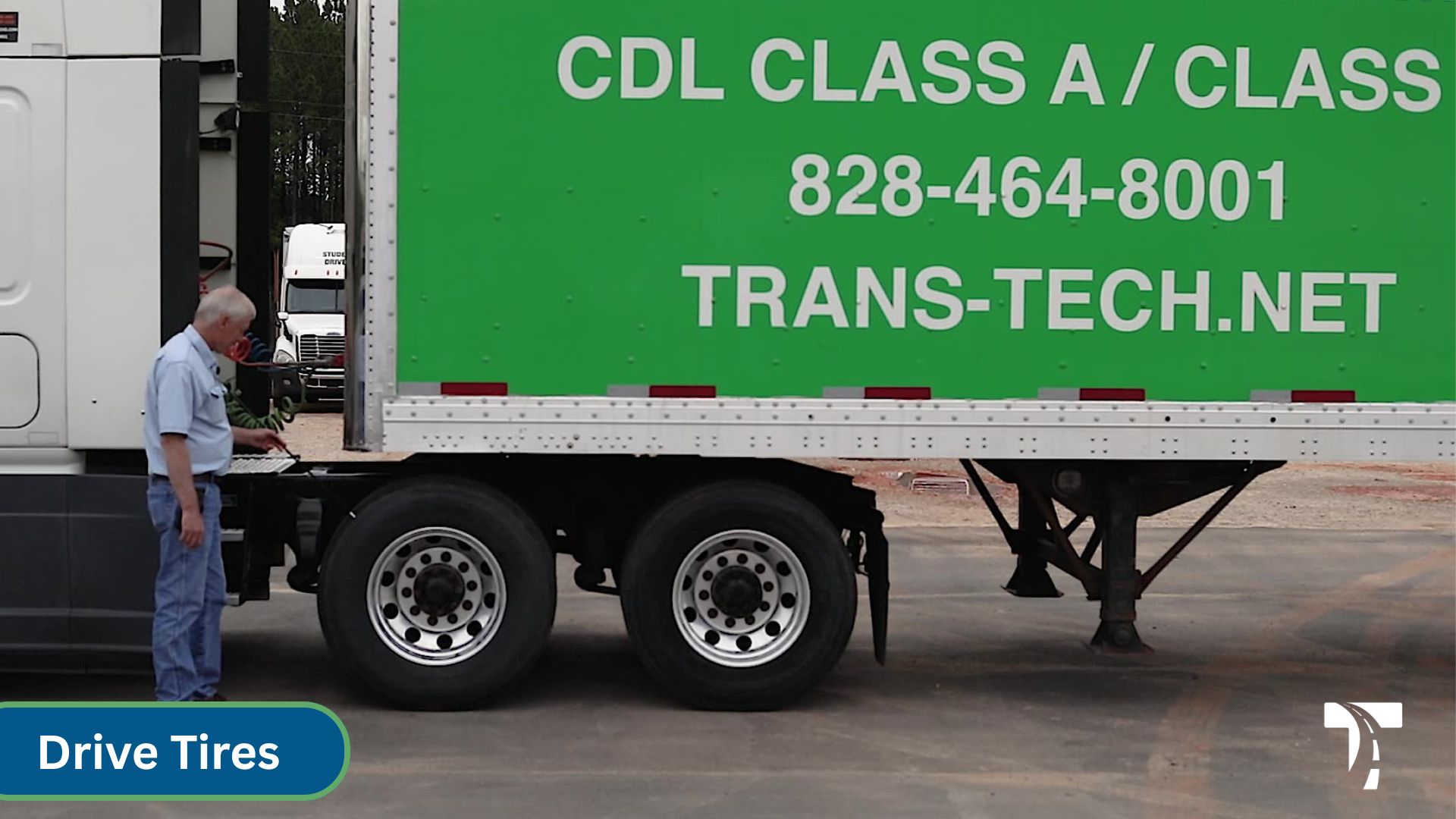 instructor standing standing at front drive tires of semi cab