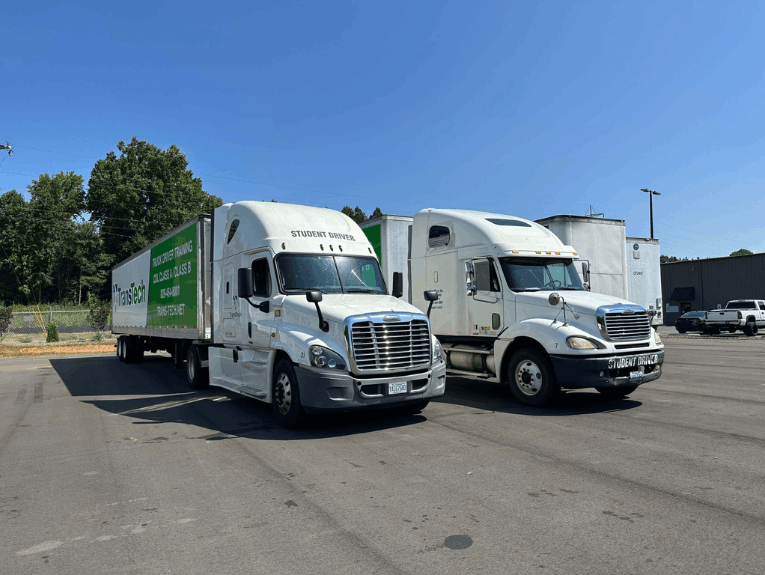 Two trucks parked side-by-side in paved training lot