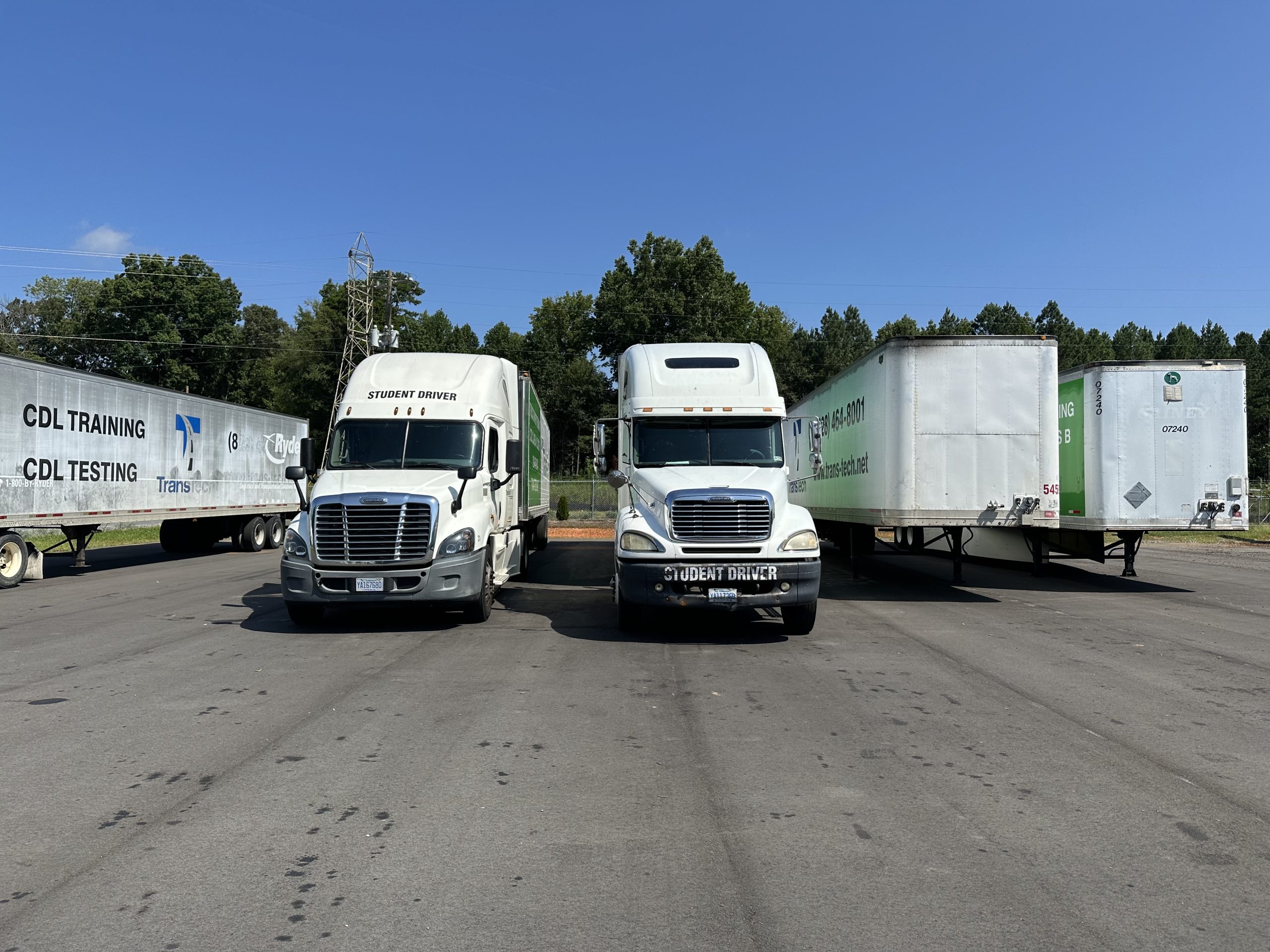 Five TransTech semi trucks parked, two facing forward and three facing backward