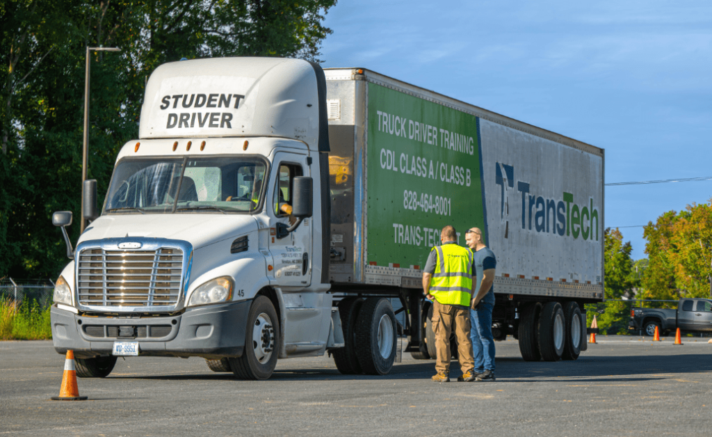 Students and one instructor standing near a parked TransTech semi truck