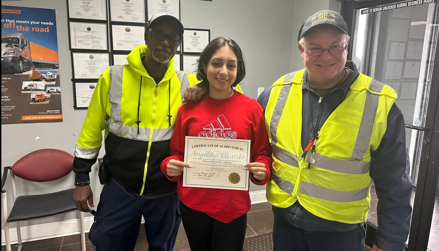 charlotte graduate smiling with certificate and instructors