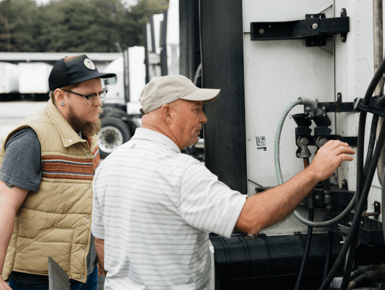 Instructor showing student the airlines on a semi truck