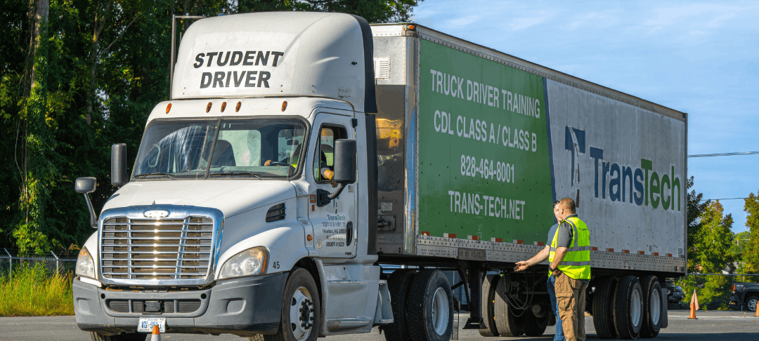 Students and one instructor standing near a parked TransTech semi truck