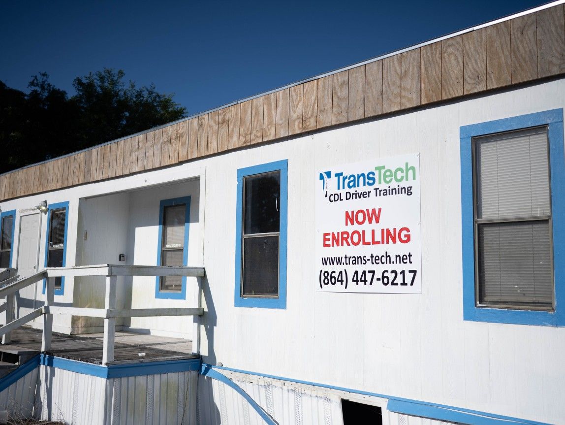 Front of Charleston campus building with a TransTech enrolling sign on front