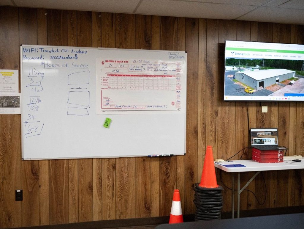 Charleston classroom wall with a whiteboard with CDL training material written and a TV