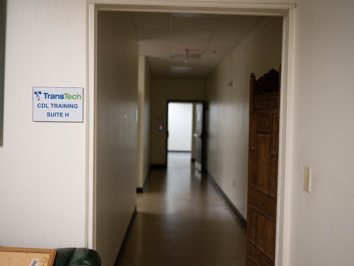 Long hallway with a TransTech plaque on the wall, directing people to the suite.