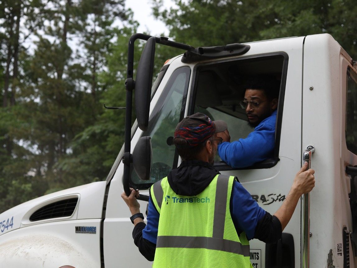TransTech CDL instructor coaching a student driver in a semi-truck cab