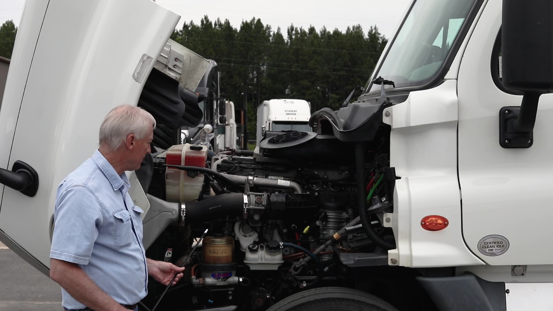 instructor examining interior of semi truck cab