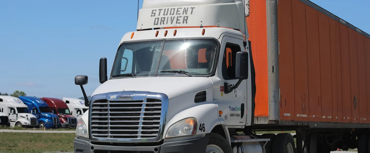 TransTech semi-truck parked in training yard with a fleet of trucks behind
