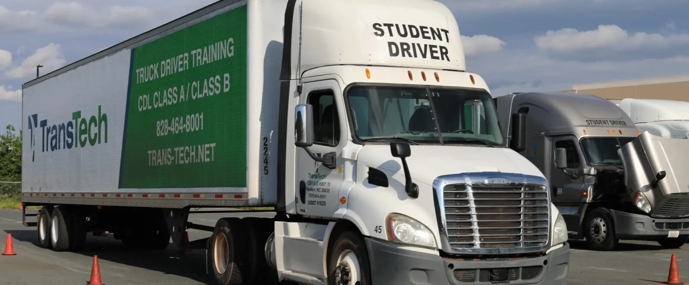 A TransTech student driver navigates a semi-truck through a cone course