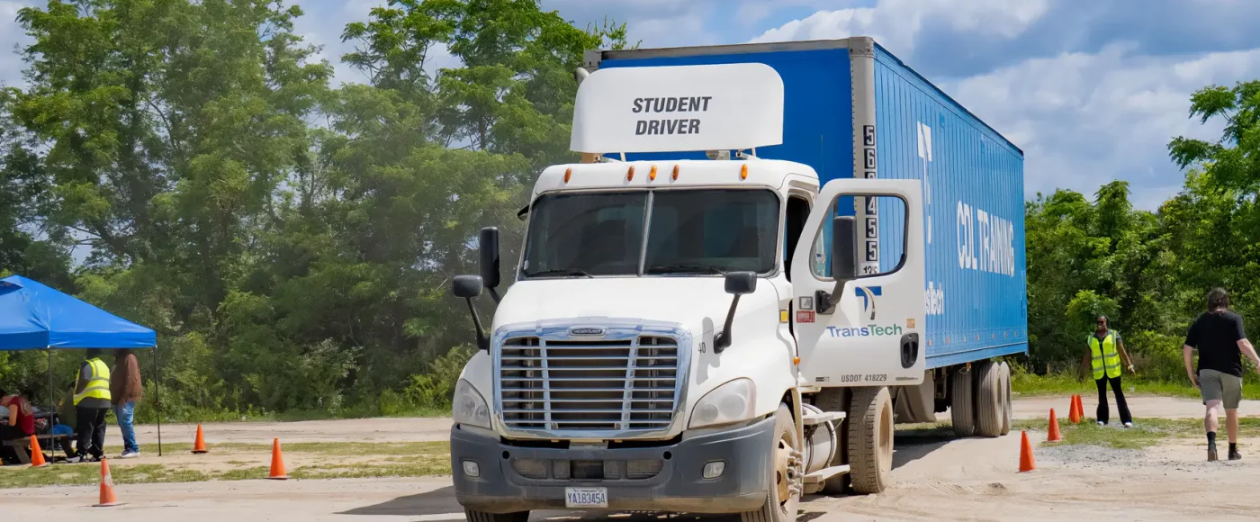 Fayetteville campus training yard with a semi truck and students sitting under a tent