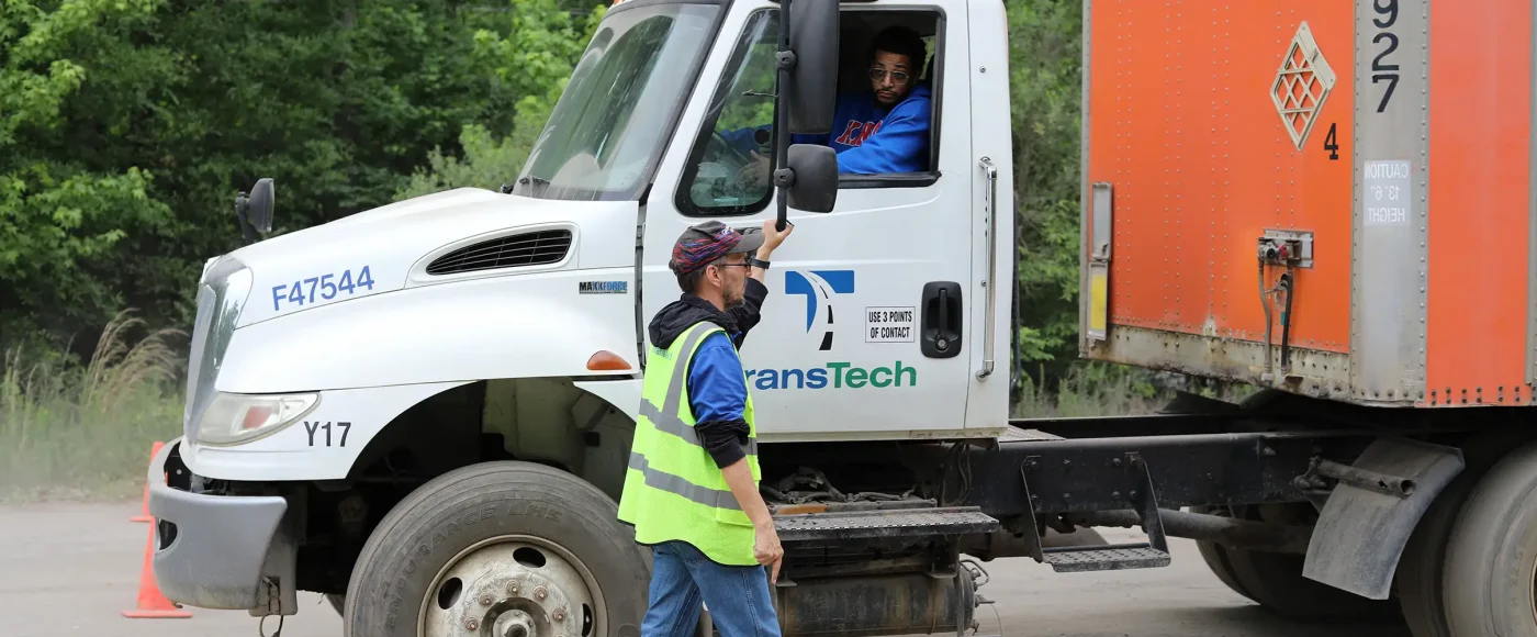 TransTech instructor guiding a student driving a semi truck
