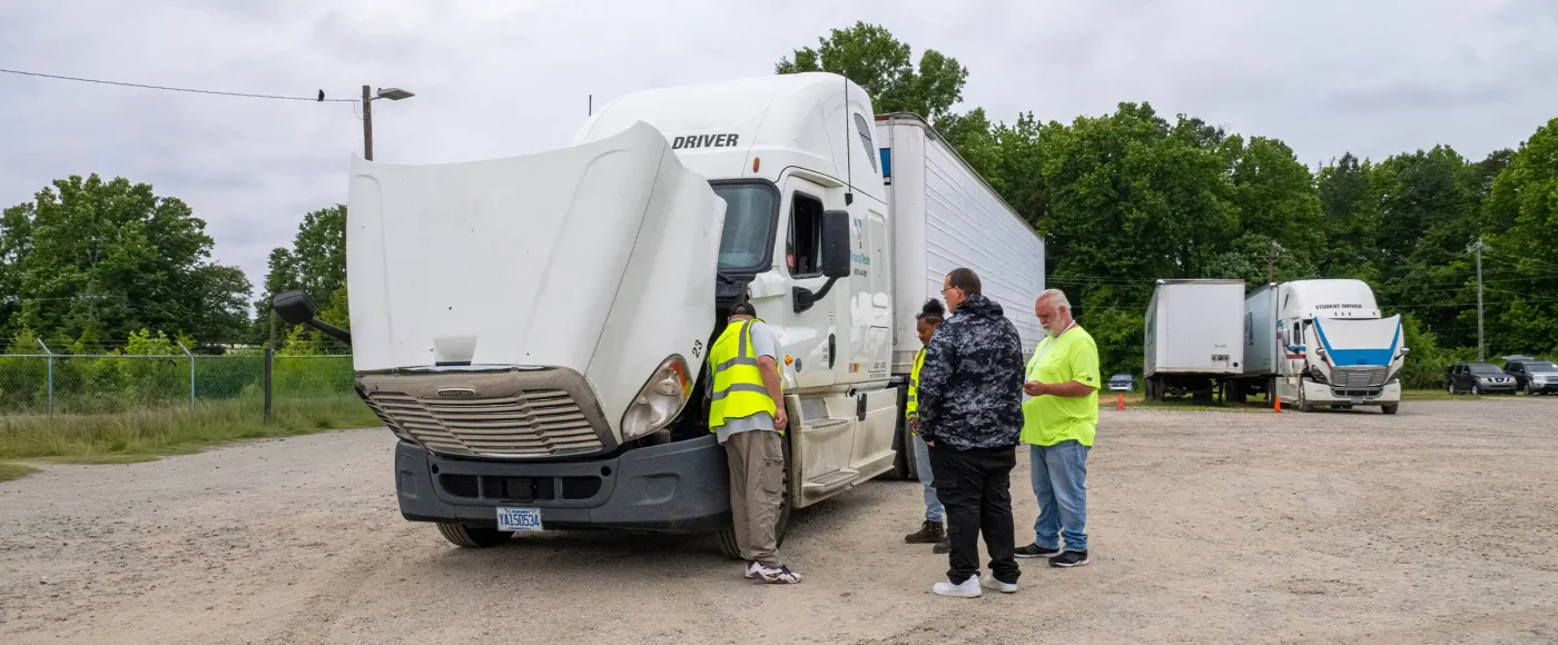 CDL instructors and students performing a pre-trip inspection on a semi-truck at Greensboro