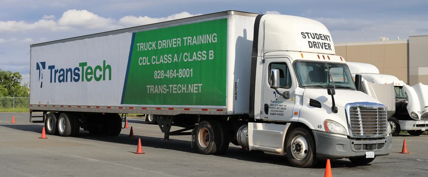 TransTech semi truck parked in training yard, with cones surrounding it and other semi trucks