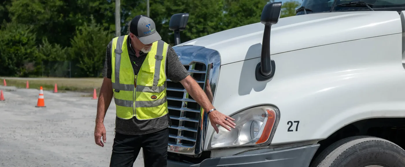 TransTech instructor pointing to the semi truck headlight