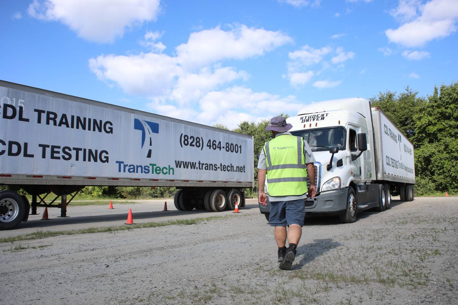 TransTech instructor walking toward two semi trucks in training yard